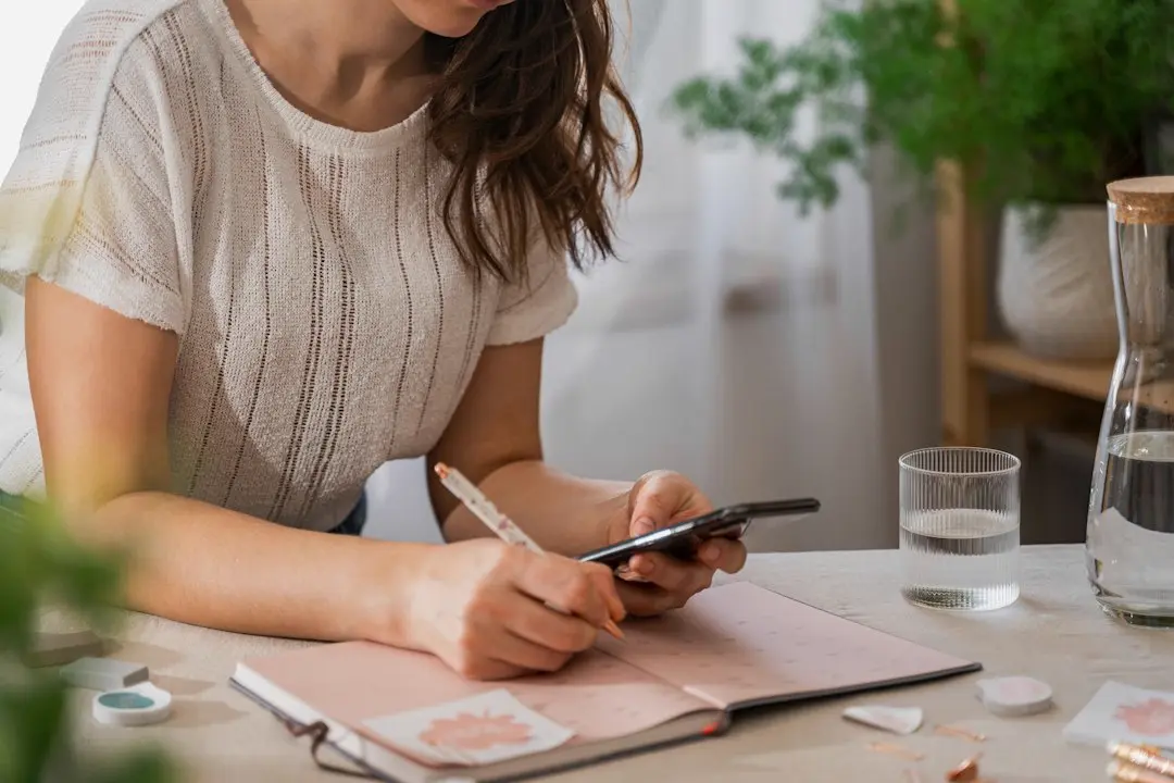 手帳と電卓でお金の準備計画を立てる日本人女性